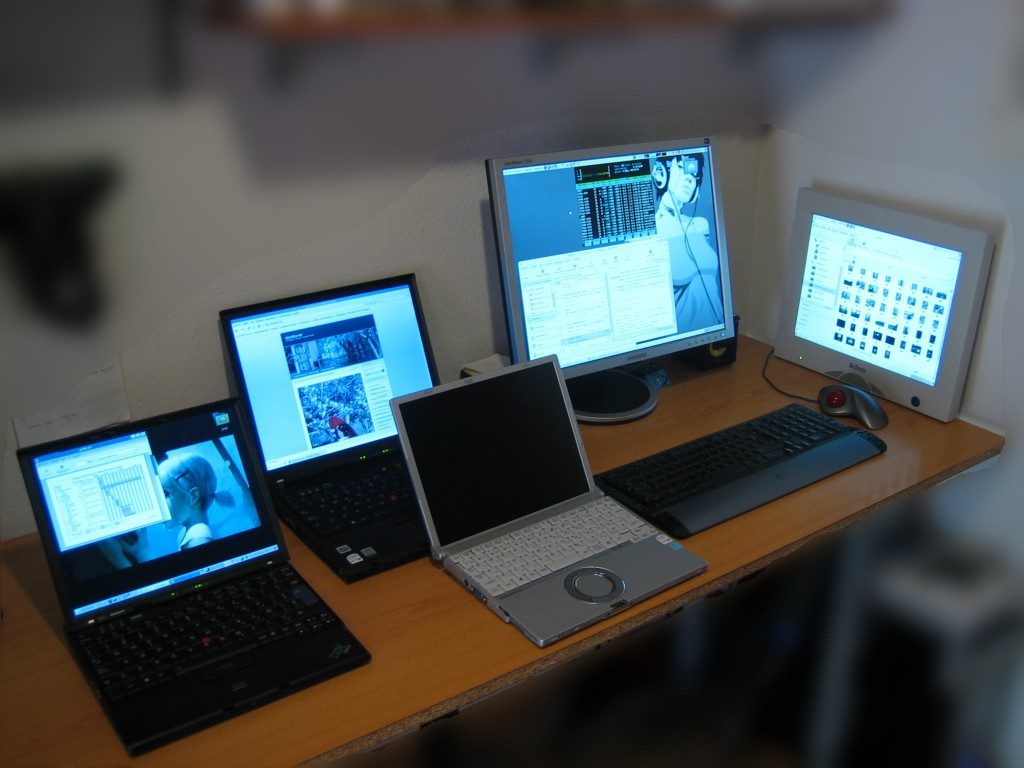 multiple desktops on a wooden table